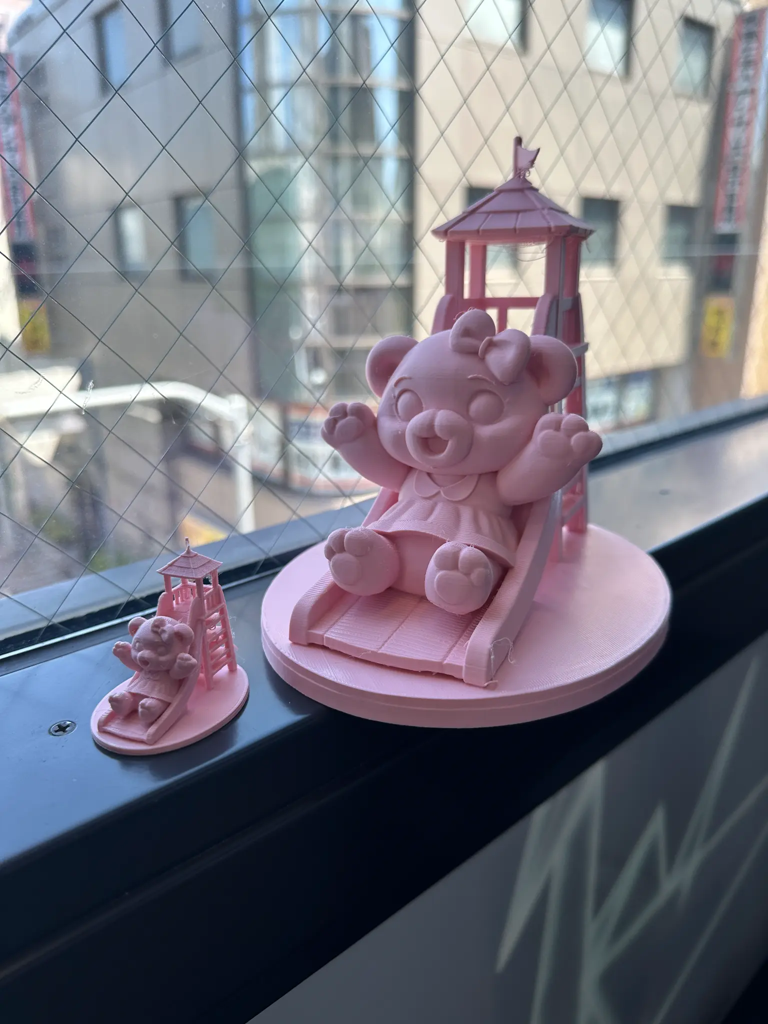 滑り台に乗るピンク色の動物の3D作品